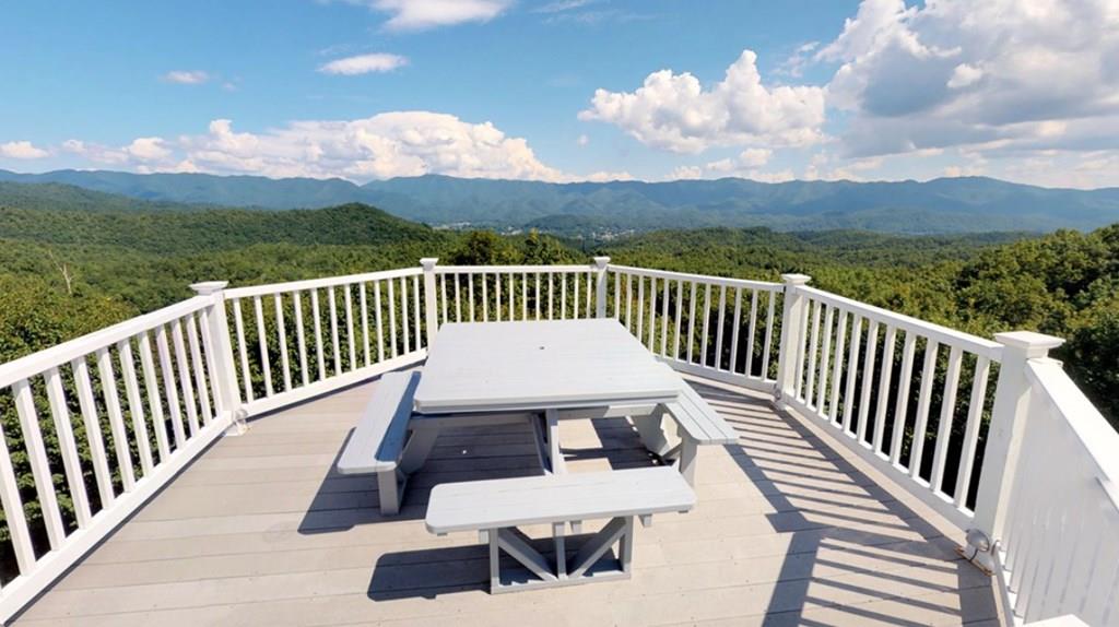 a view of a balcony with wooden floor and a floor to ceiling window