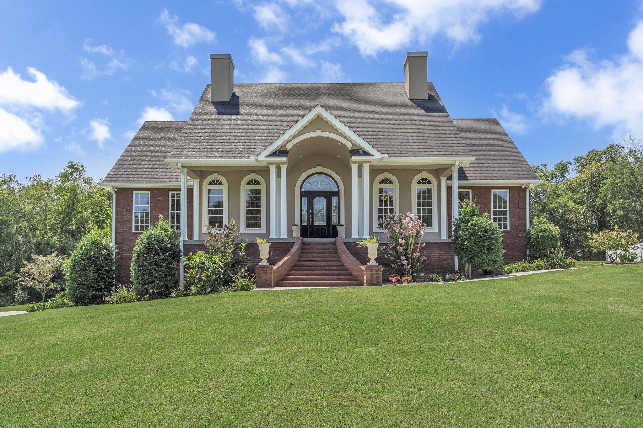 a front view of a house with a garden