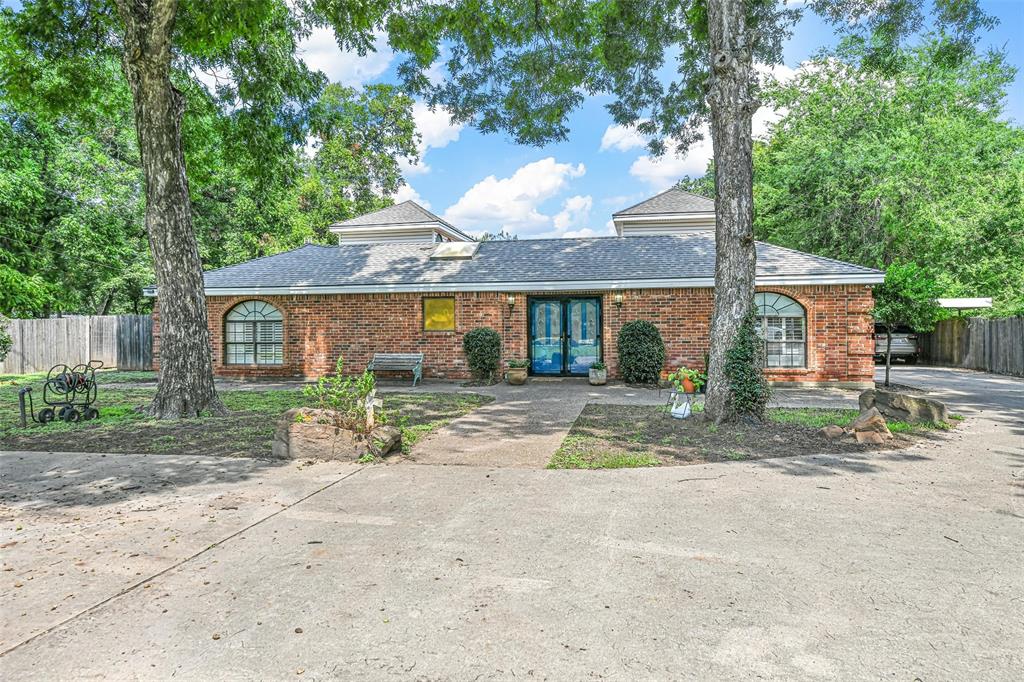 a view of a house with a yard and large tree