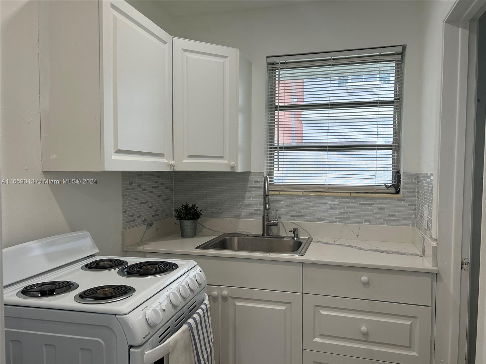 a kitchen with sink a stove and cabinets