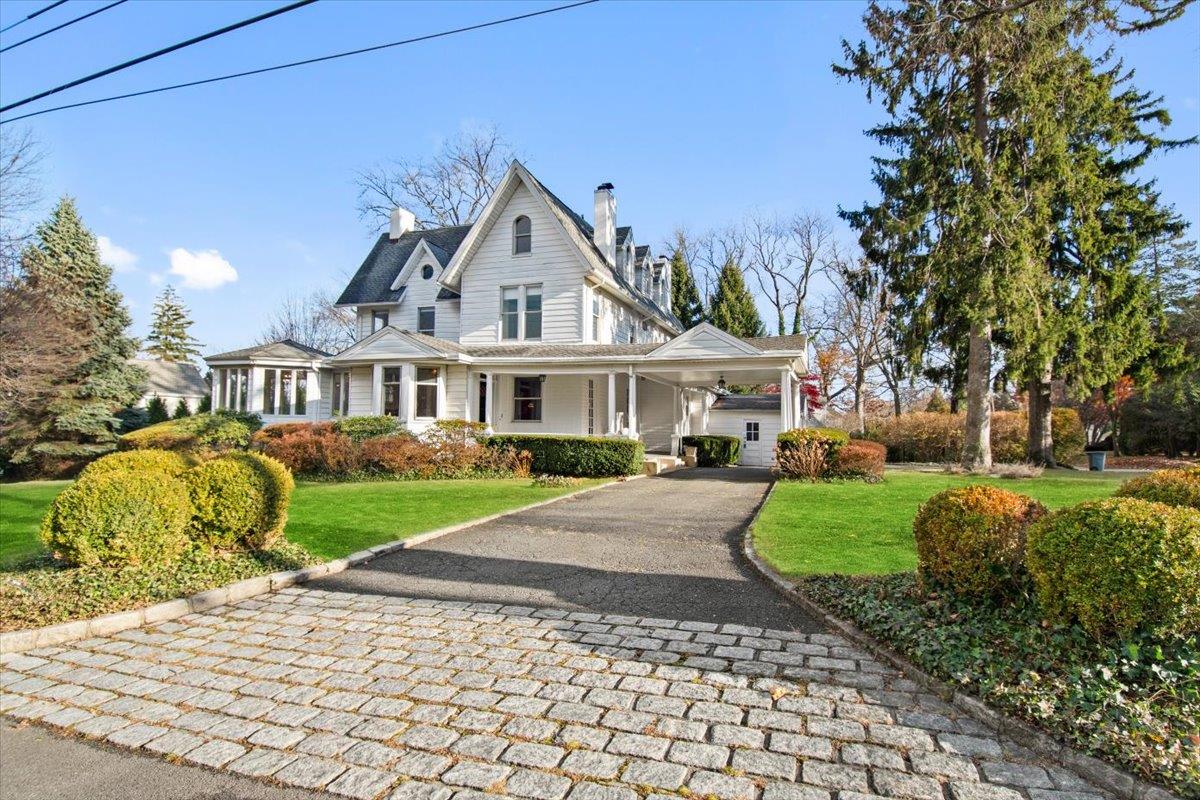 View of front facade with a front yard and a carport