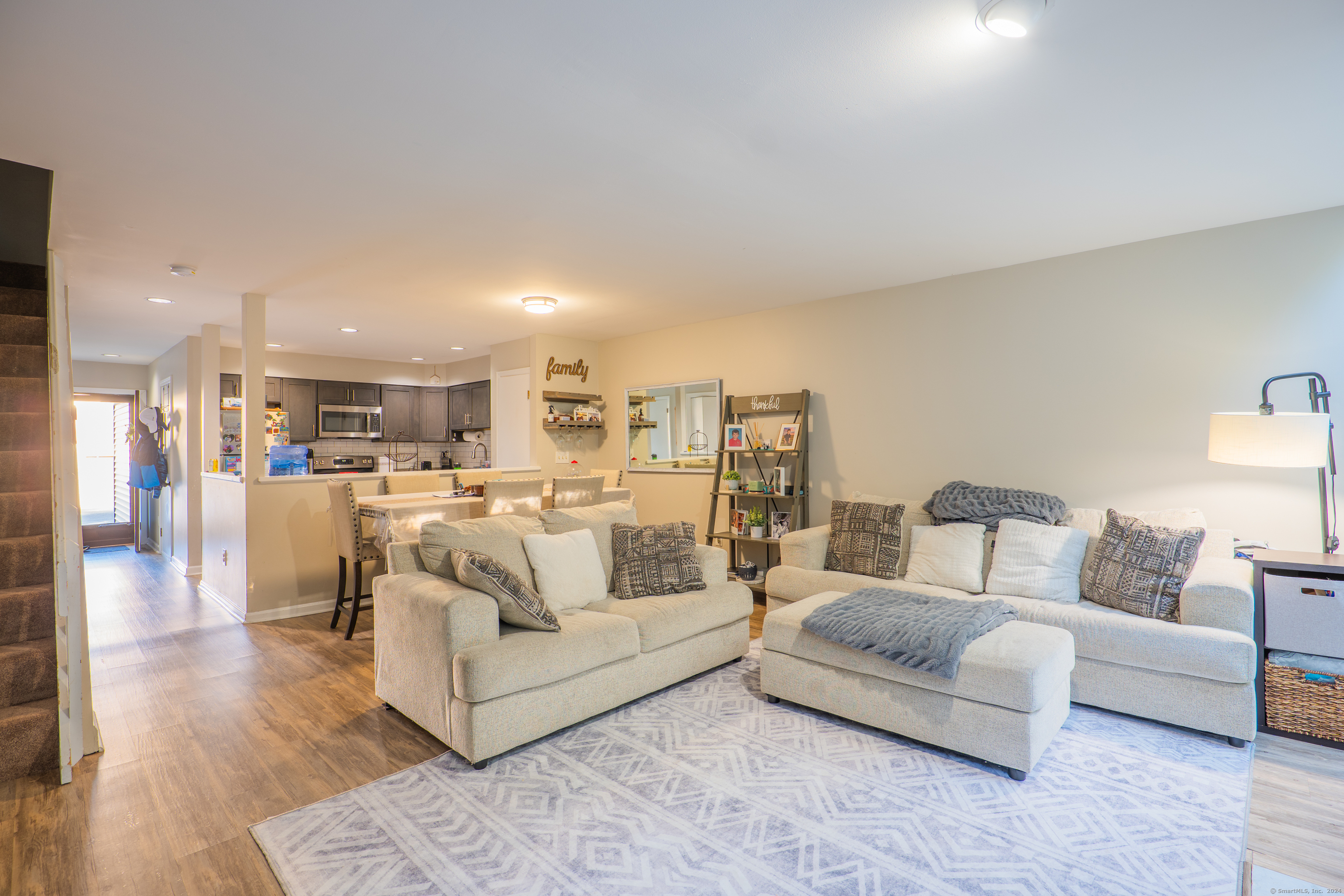 a living room with furniture and view of kitchen