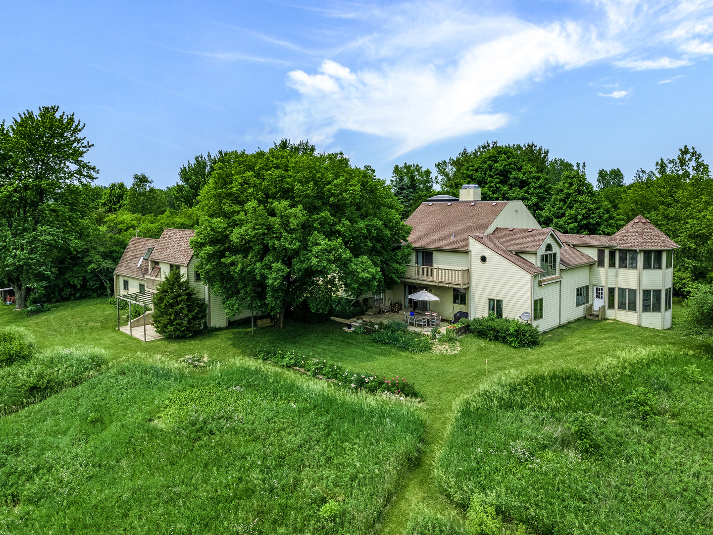 a view of a house with a big yard plants and large trees