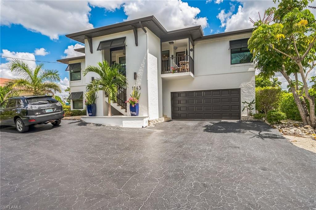 View of front of property featuring a balcony and a garage