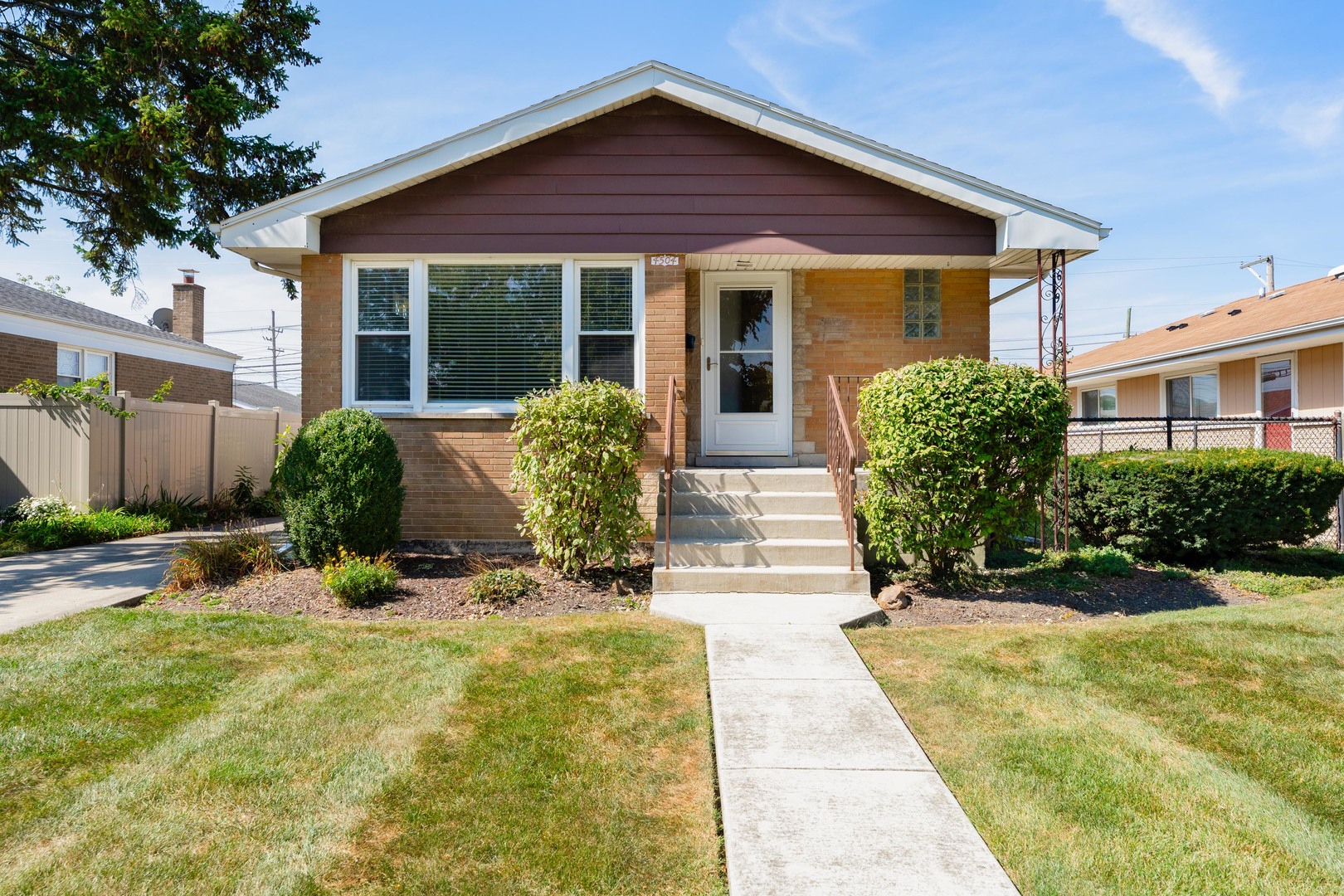 a front view of a house with a yard and potted plants