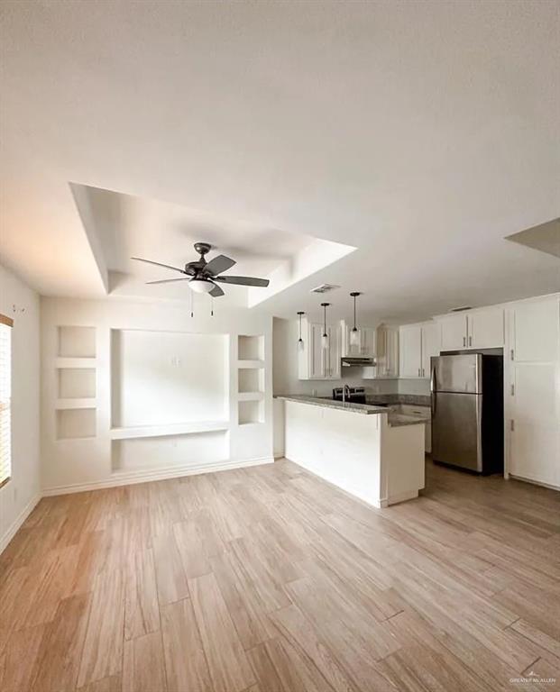 a view of a kitchen with a sink a refrigerator and wooden floor