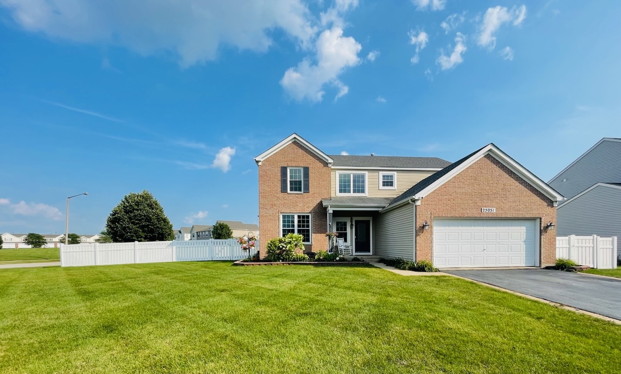 a front view of house with yard and trees in the background