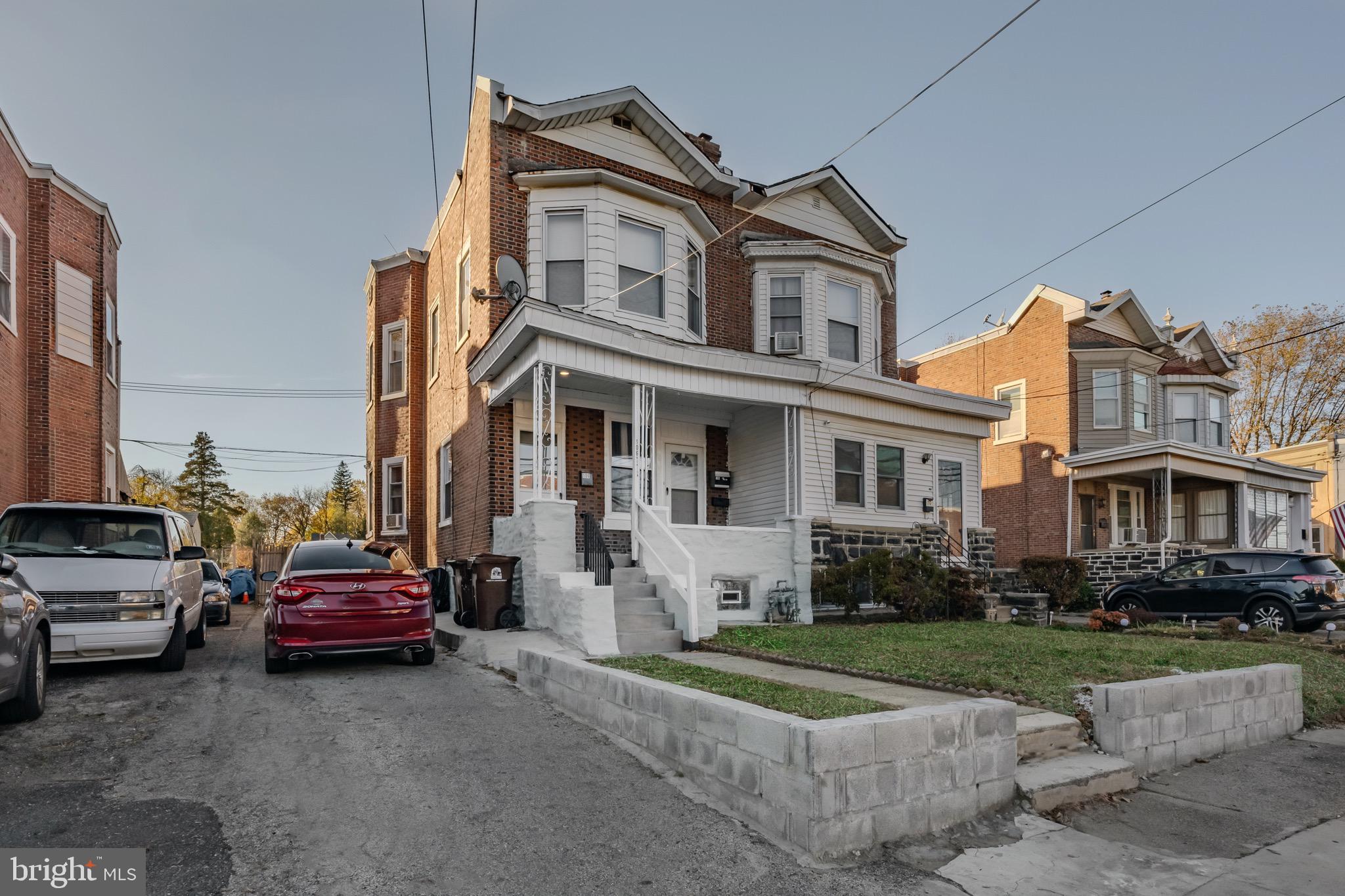 a front view of a house with cars parked