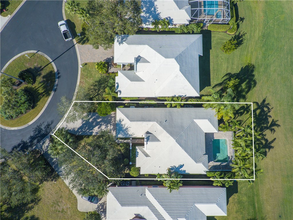 an aerial view of a house a yard and a fountain