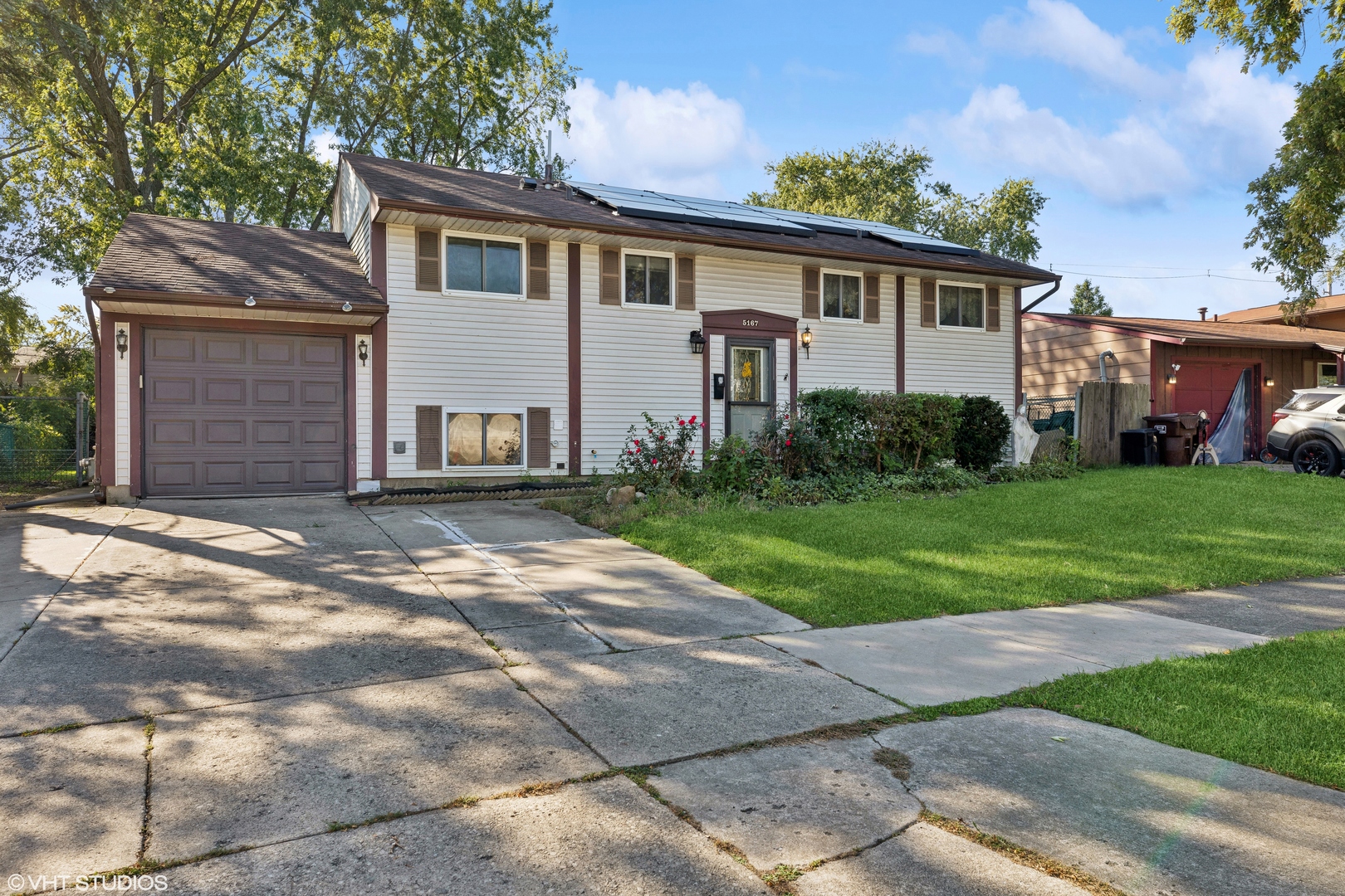 a front view of a house with yard and green space