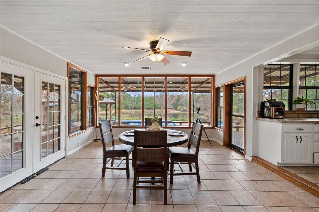 a dining room with furniture a chandelier and large window