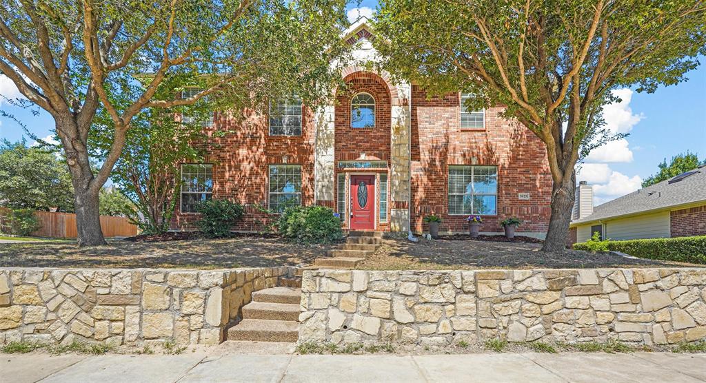 a view of a brick house with a large tree