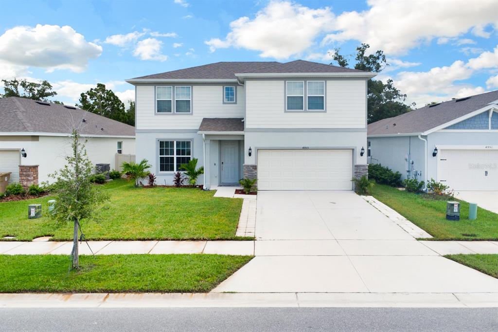 a front view of a house with a yard and garage