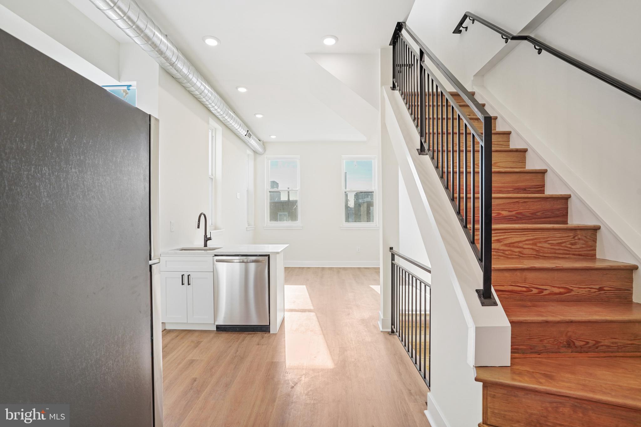 a view of a kitchen with wooden floor and electronic appliances