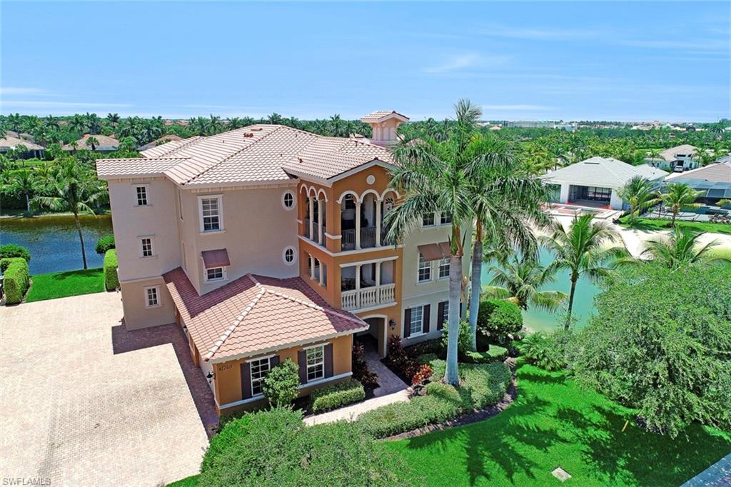 an aerial view of a house with a yard and table and chairs under an umbrella