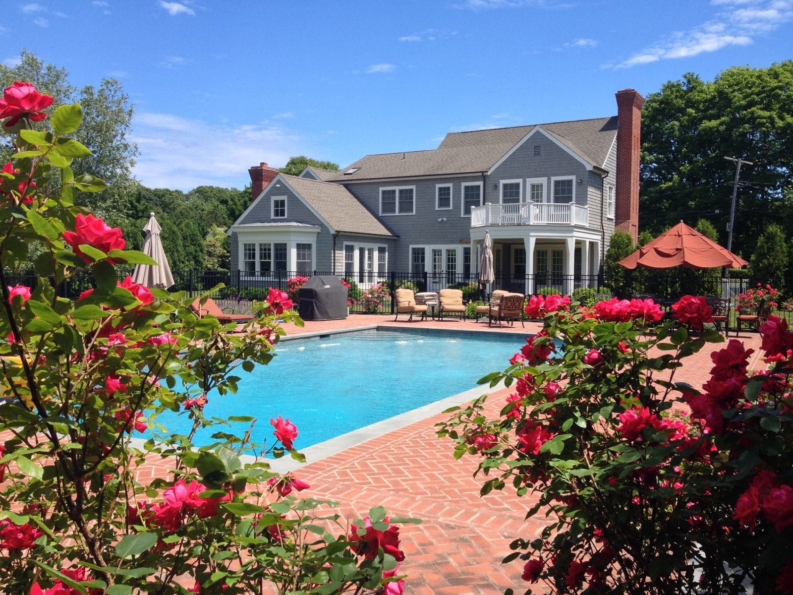 a front view of a house with swimming pool and garden