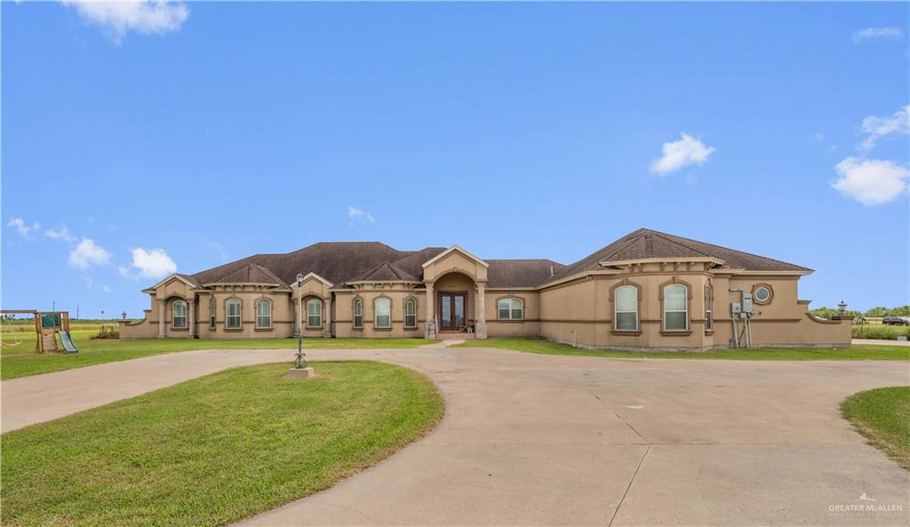 a large house with a big yard and large trees