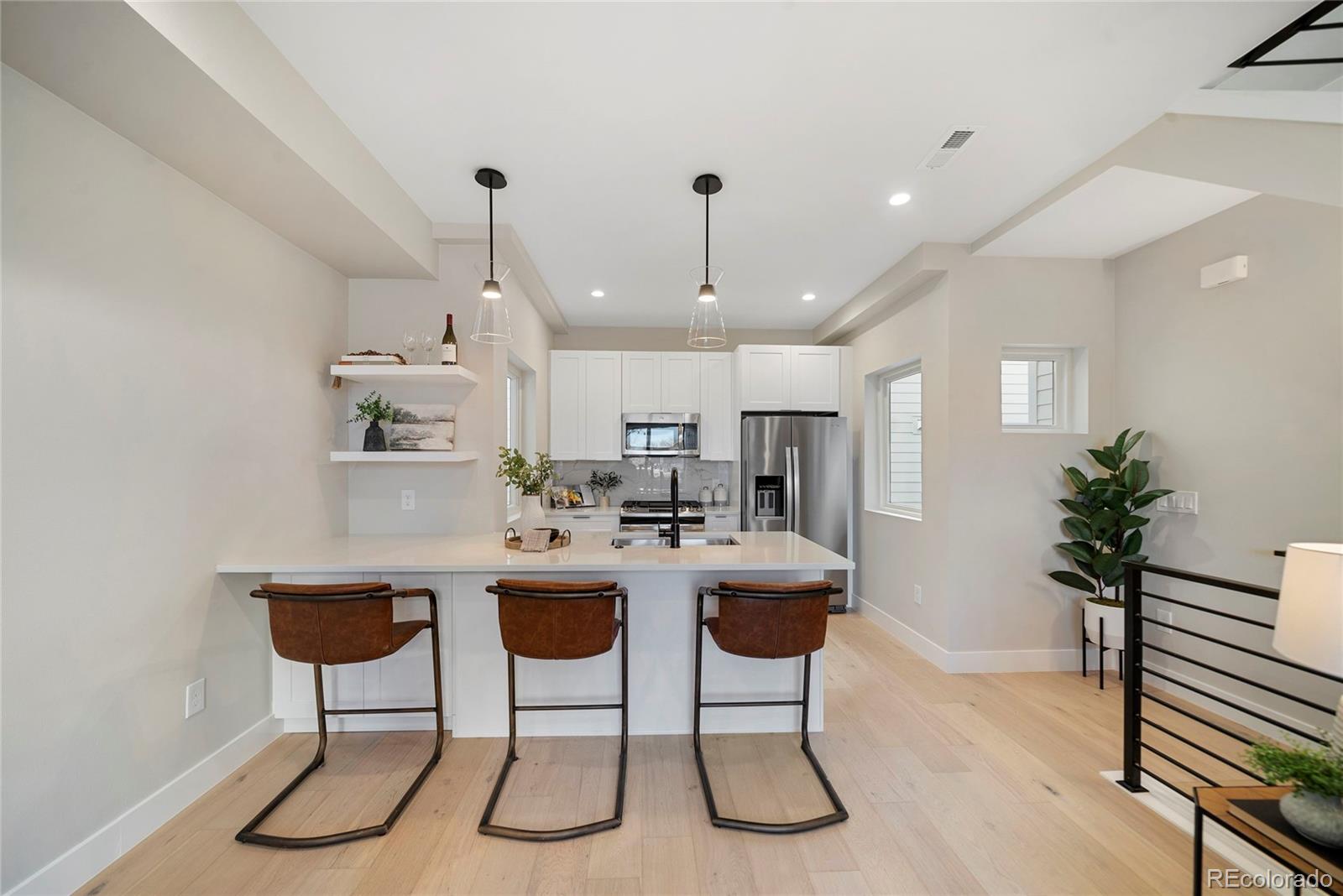 a kitchen with kitchen island a dining table chairs sink and cabinets