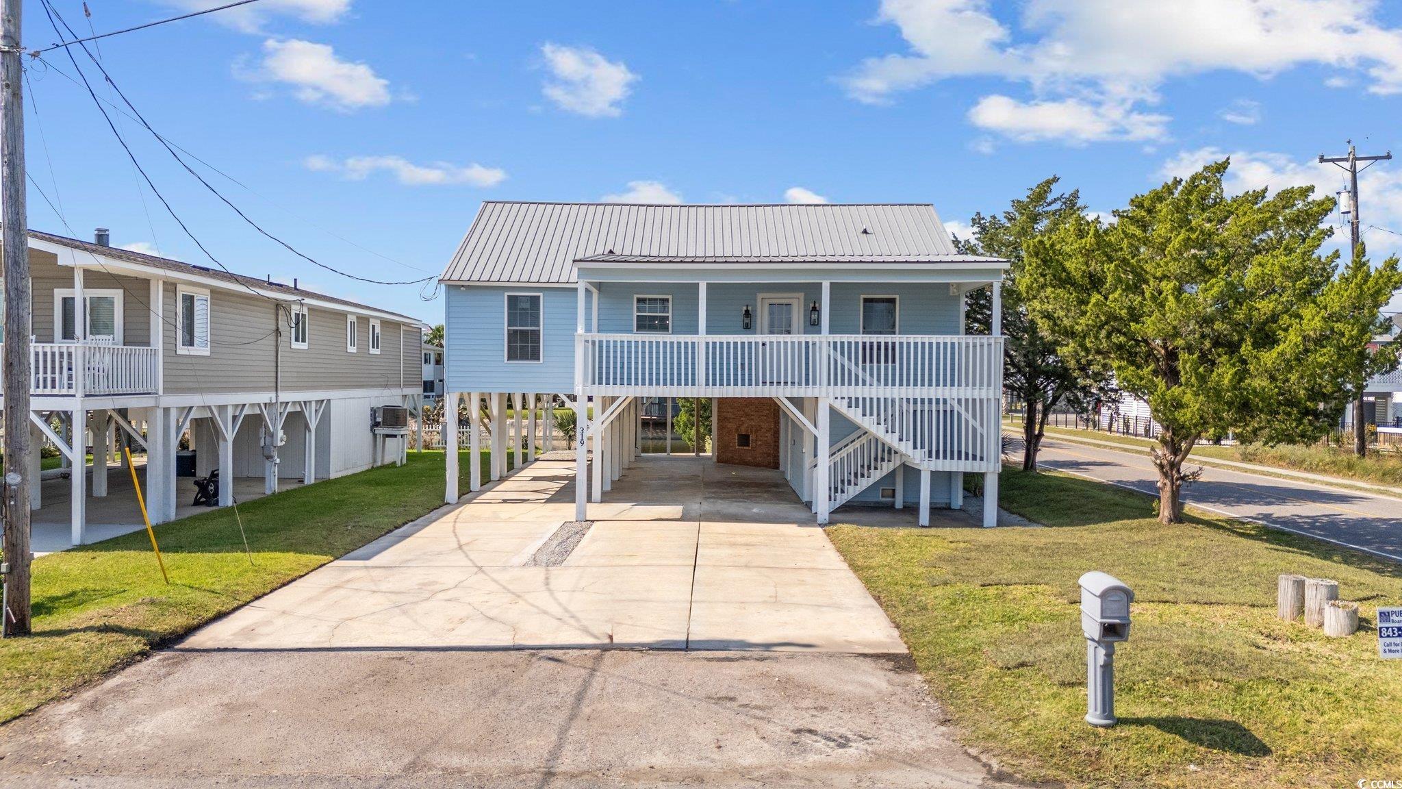 View of front of house featuring a porch, a carpor