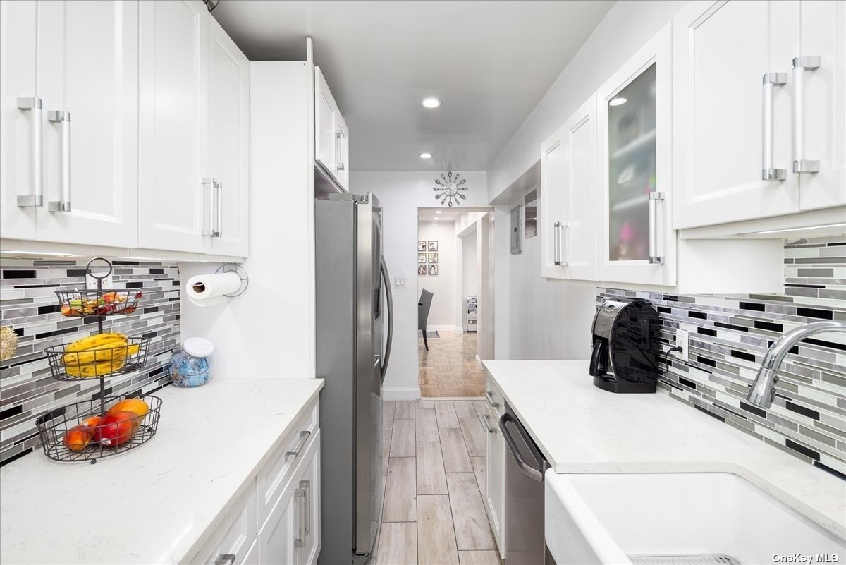 a kitchen with white cabinets and appliances