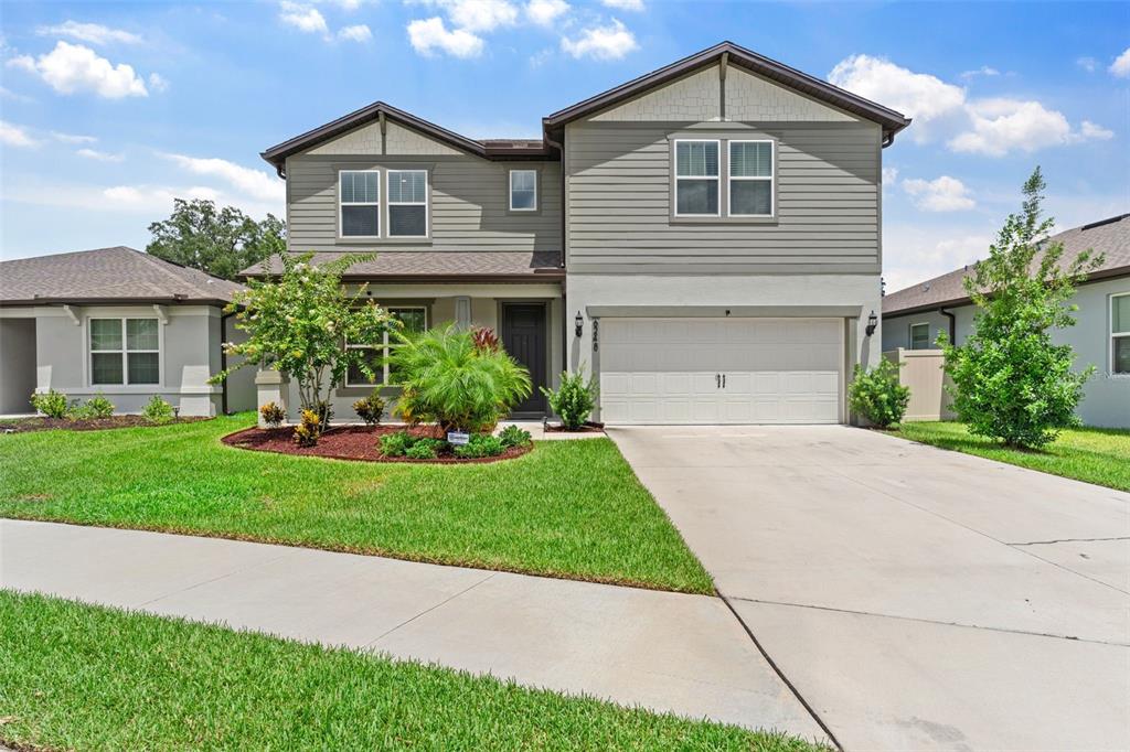 a front view of a house with a yard and garage