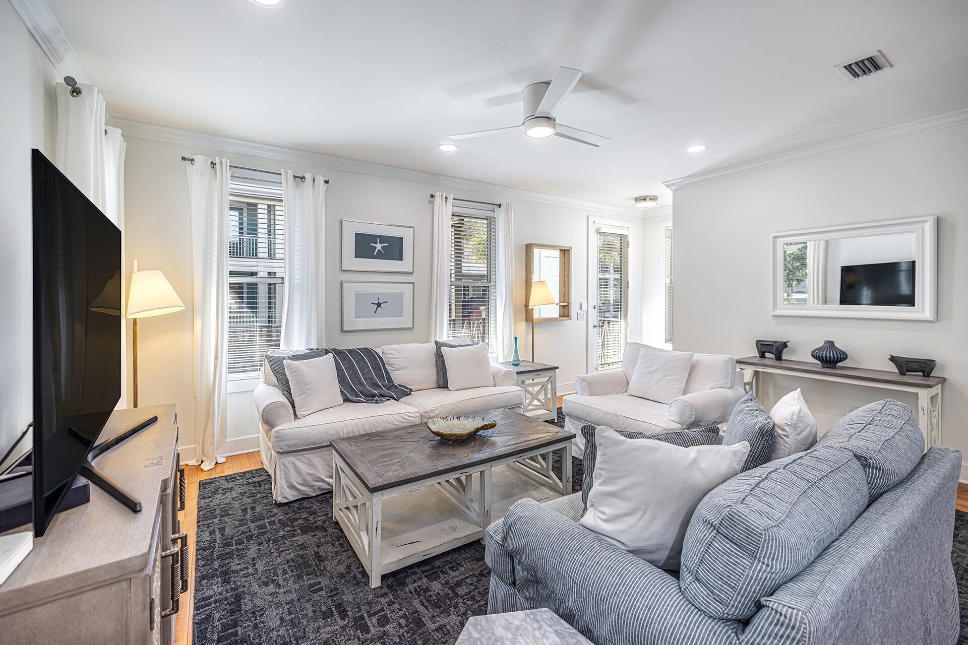 a living room with furniture a large window and a flat screen tv