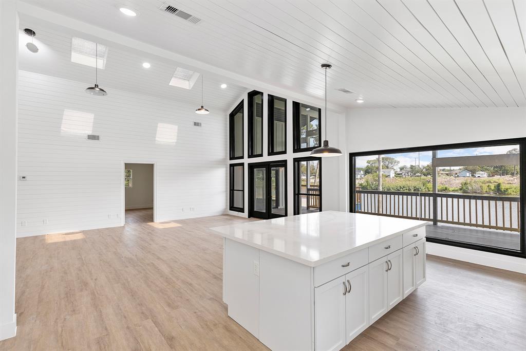 a large white room with wooden floor and windows