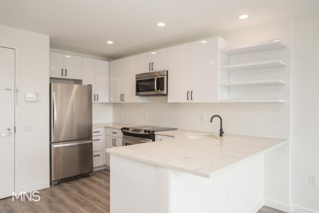 a kitchen with stainless steel appliances a refrigerator sink and microwave