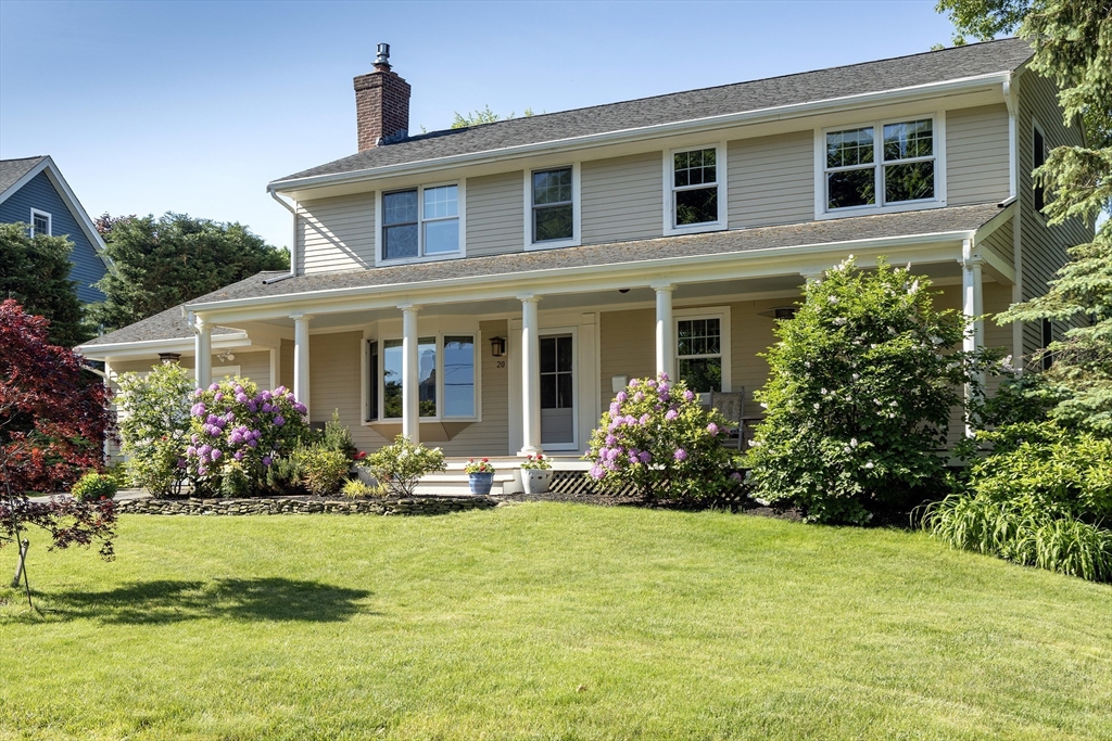 a front view of a house with a yard and fountain