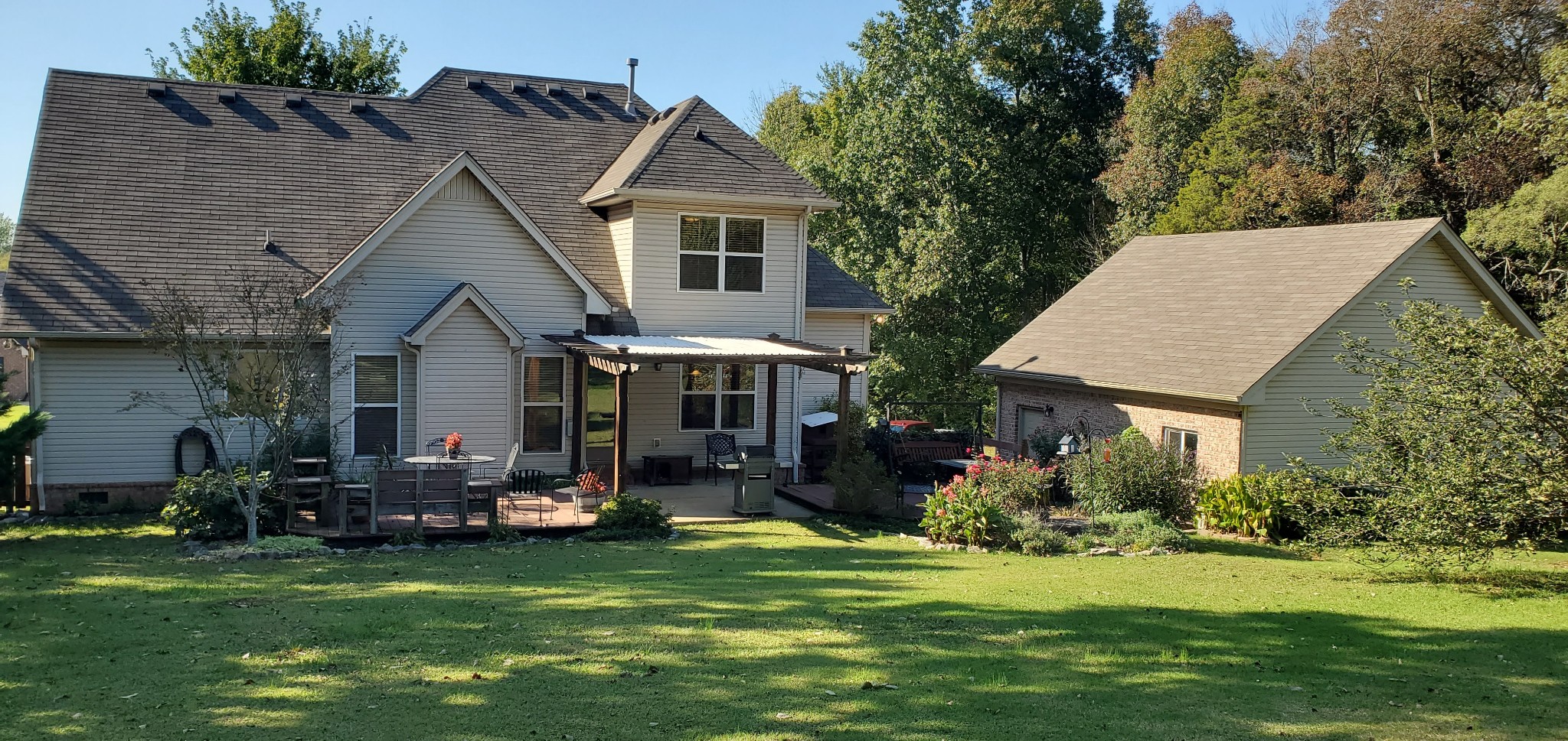 a front view of a house with a garden and trees