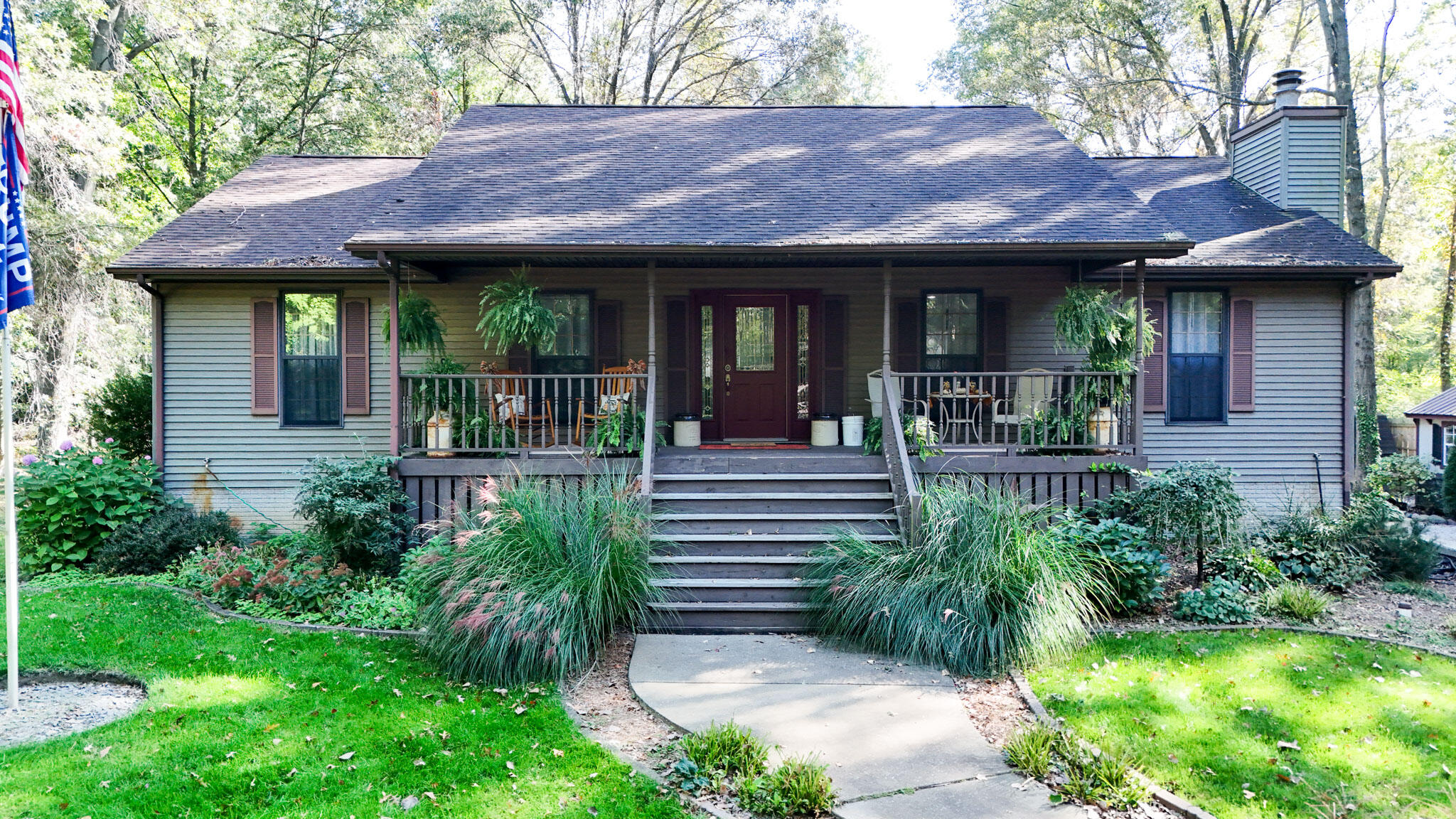 a view of a house with a small yard plants and large tree