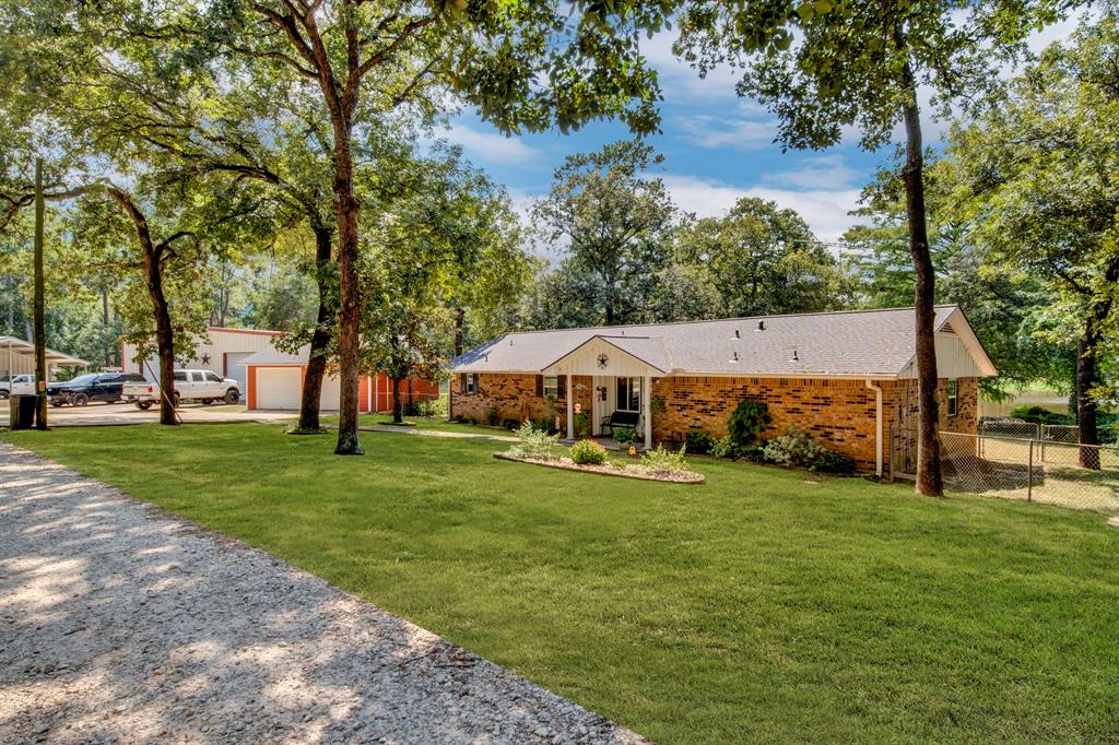 a view of a house with a big yard and large trees