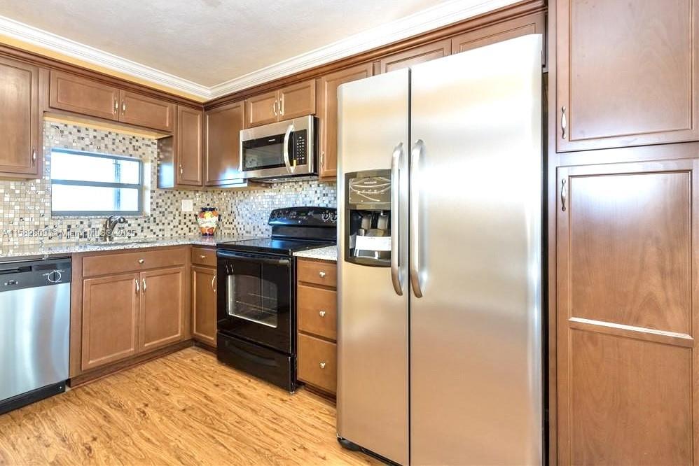 a kitchen with stainless steel appliances a refrigerator sink and microwave