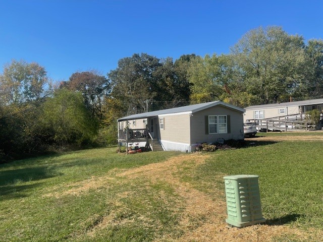 a view of a house with backyard and trees