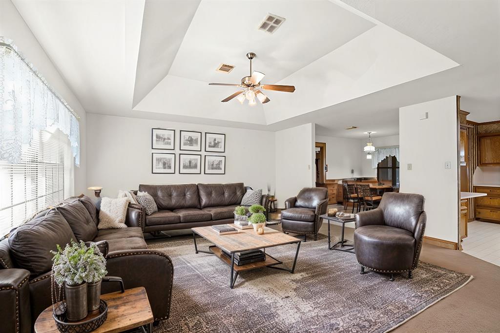 a living room with furniture a chandelier and a window