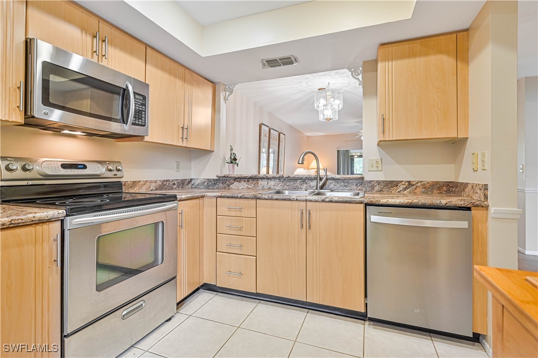 a kitchen with granite countertop white cabinets stainless steel appliances and a counter space