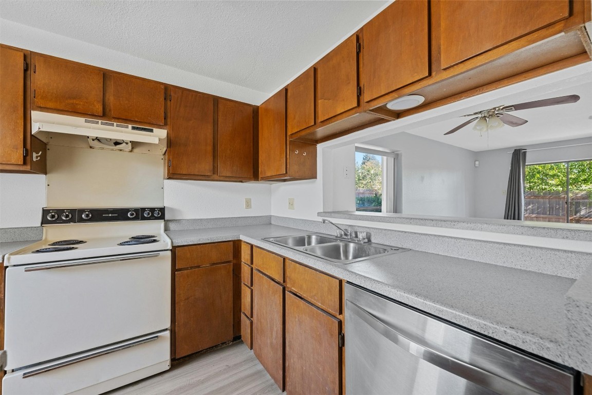 a kitchen with a sink cabinets appliances and a window