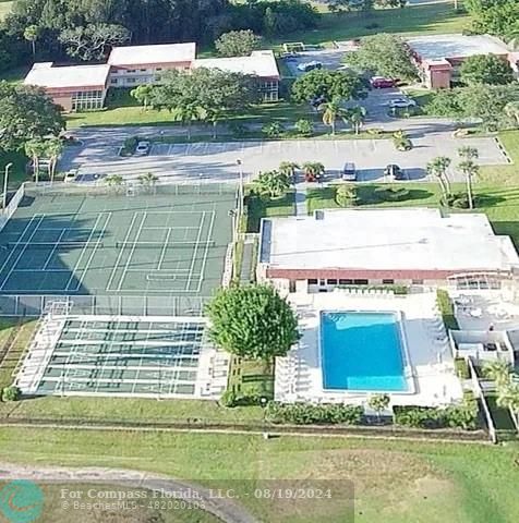 a view of a swimming pool with a yard and plants