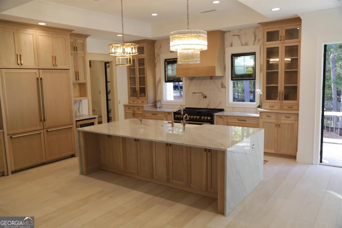 a kitchen with stainless steel appliances granite countertop a refrigerator a sink and a stove