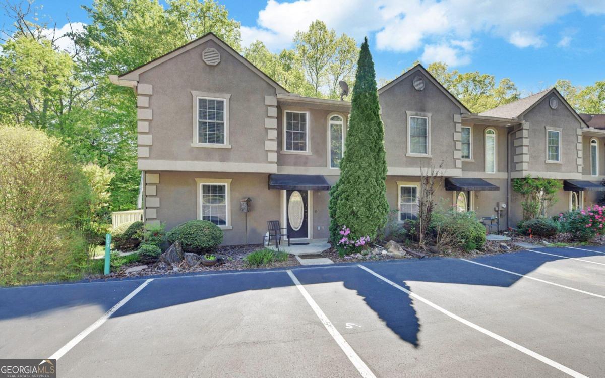 a front view of a house with yard and green space