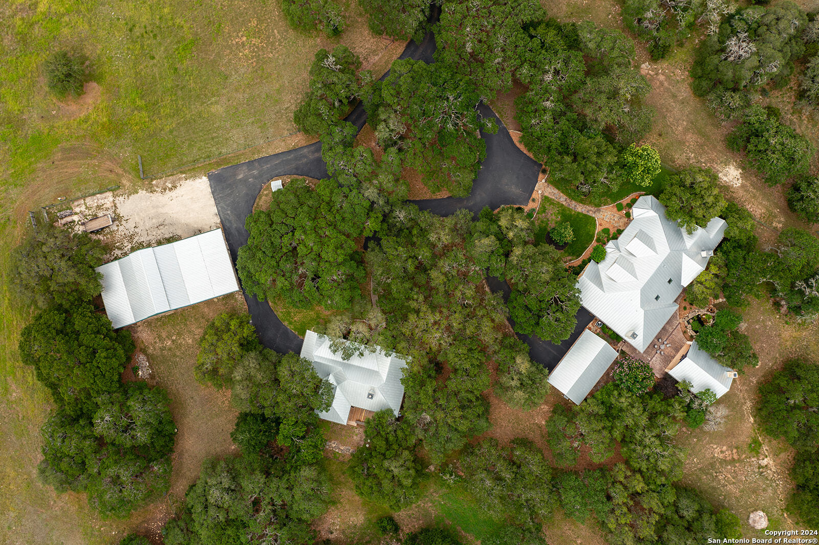 an aerial view of a house with a yard and lake view