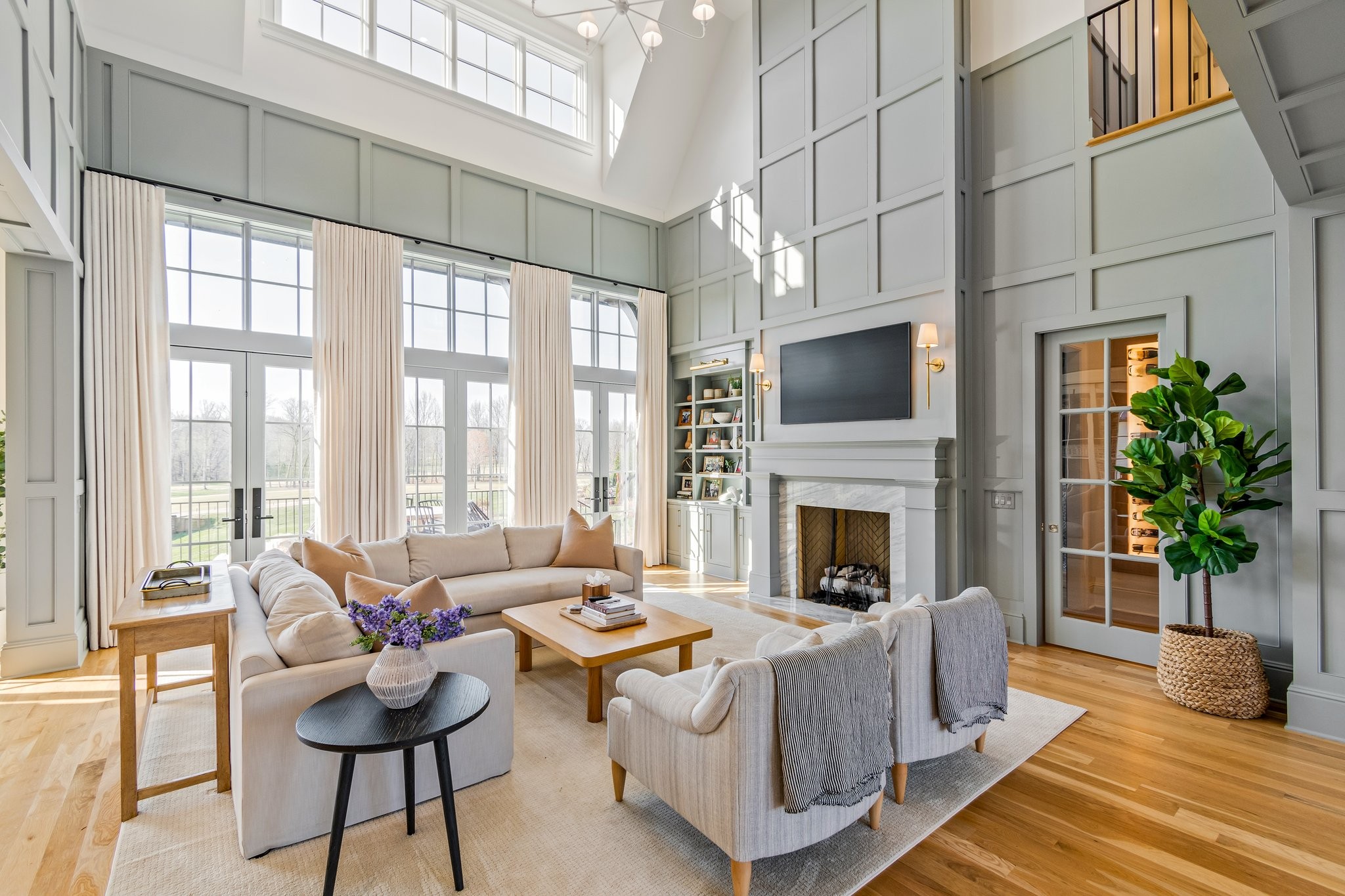 a living room with furniture fireplace and potted plants