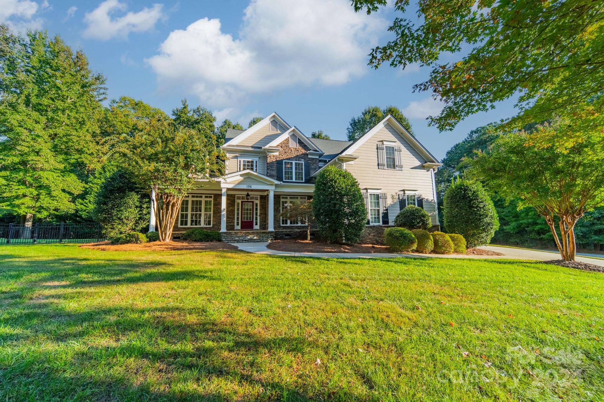 a front view of a house with swimming pool and porch with green space