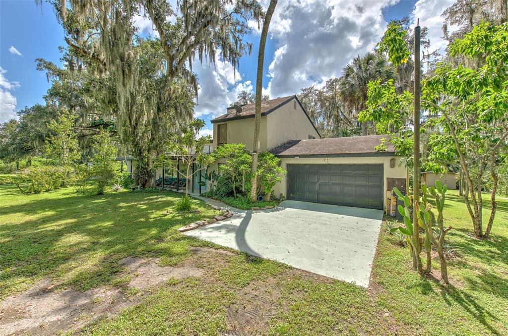 a view of a house with backyard and a tree