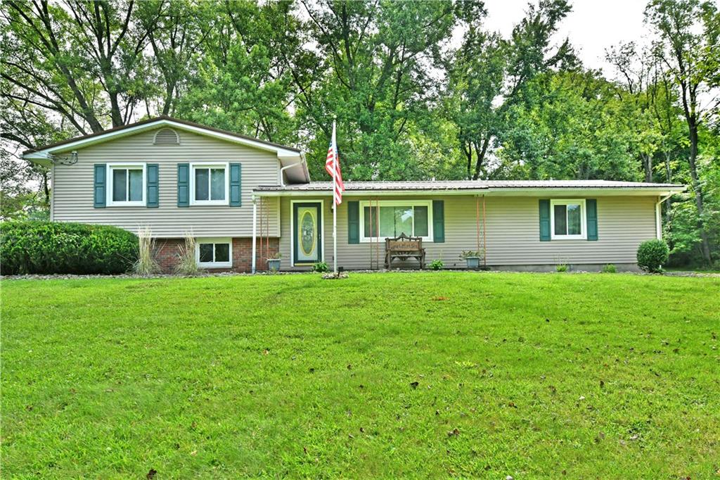 a front view of a house with a yard and trees