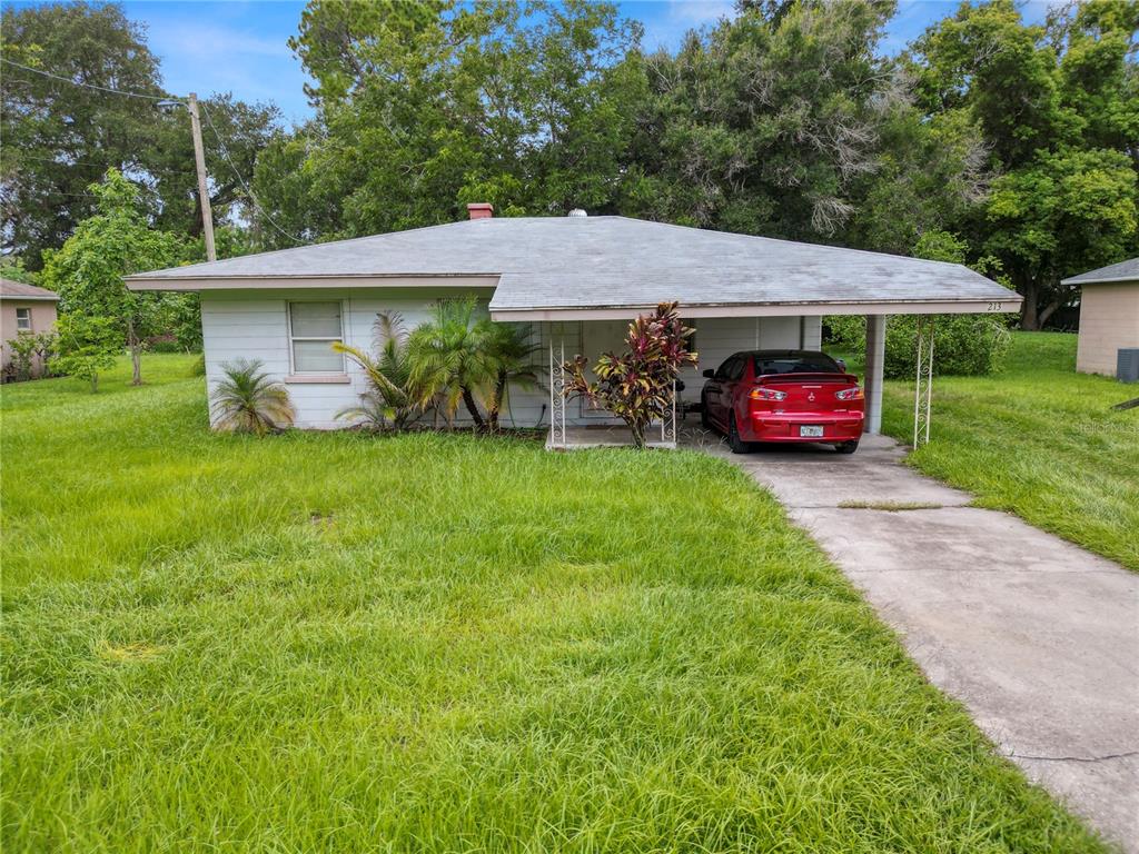 a view of a house with a yard and a car parked in it