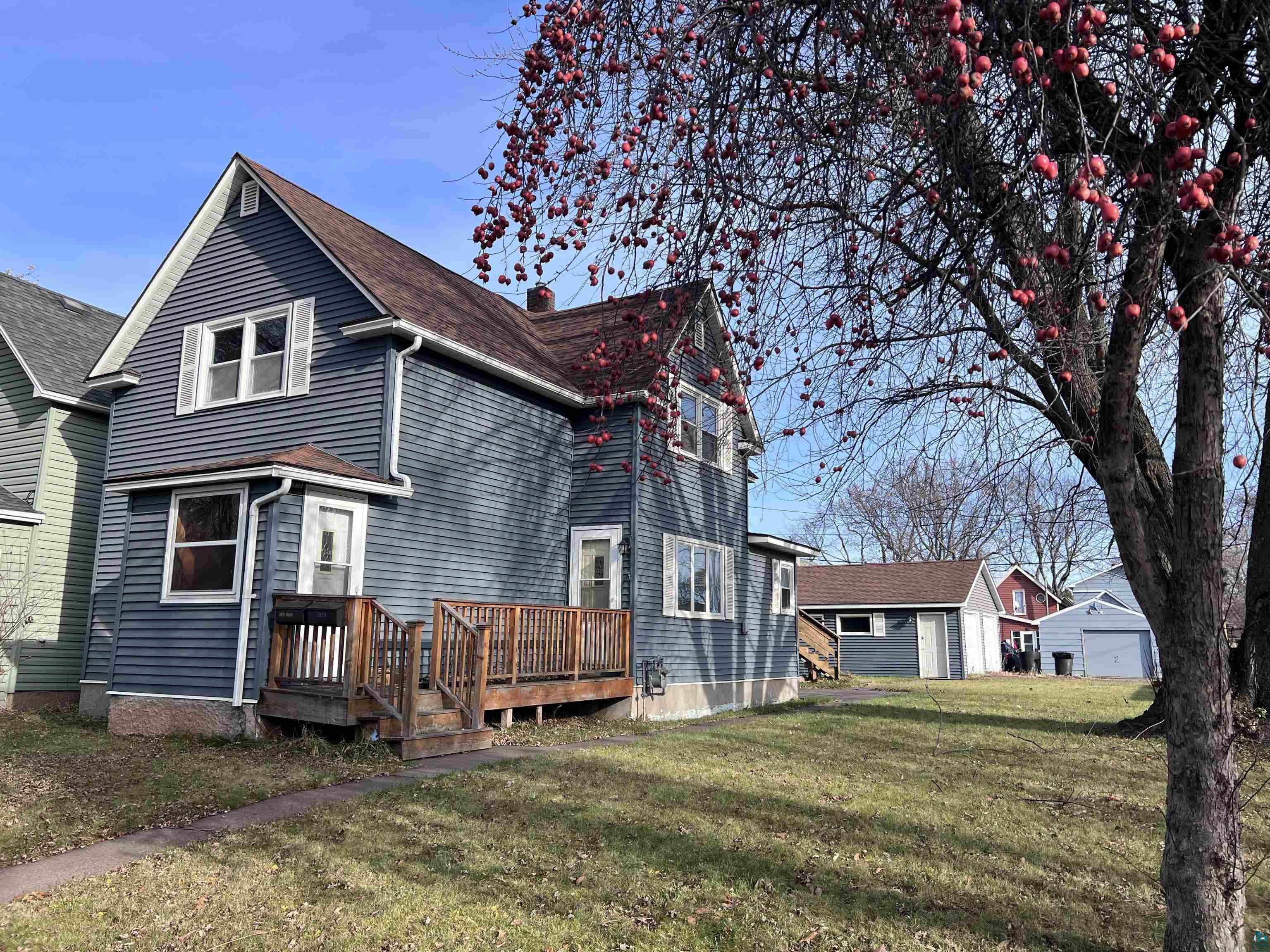 Back of house featuring a lawn and a wooden deck