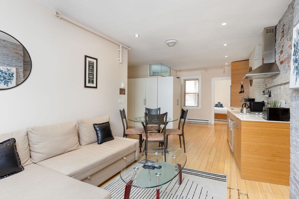 a living room with furniture a table and kitchen view