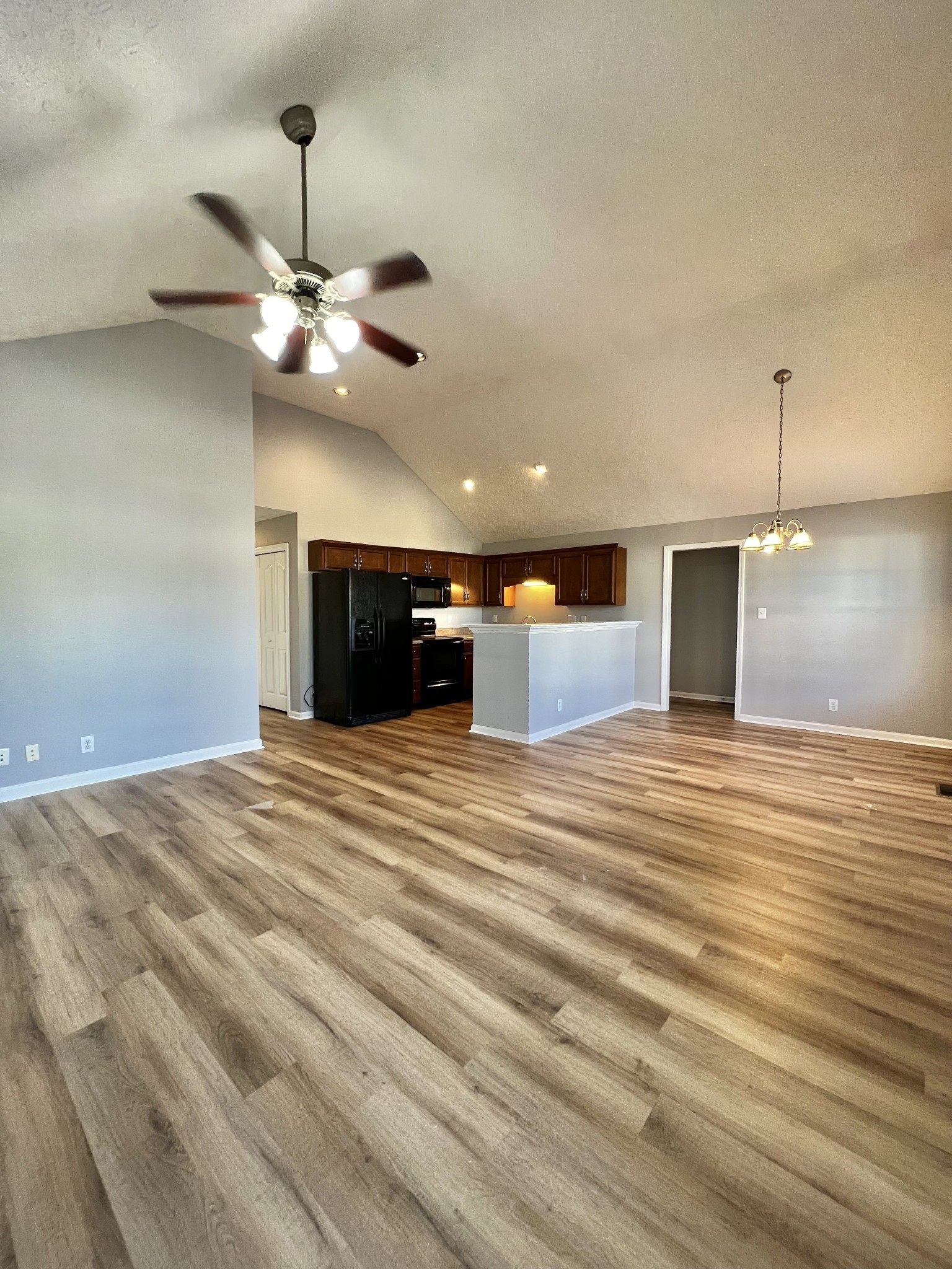 a view of a room with a ceiling fan and a wooden floor