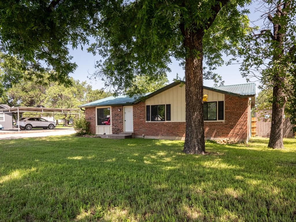 a front view of house with yard and trees